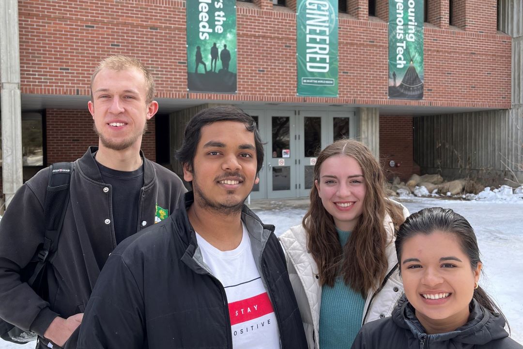 Male and female students standing in front of the USask Engineering Building 