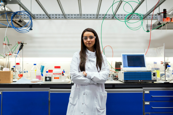 Engineering student standing in lab with white lab coat.