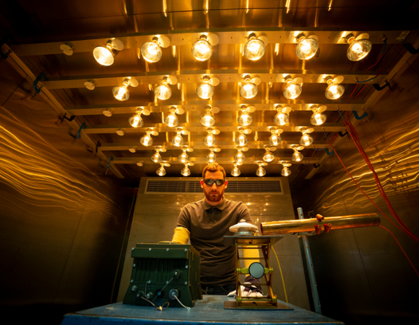 Engineer in a room with a lot of light bulbs.
