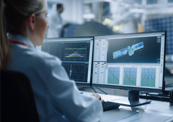 Engineer looking at a computer screen with satellites.