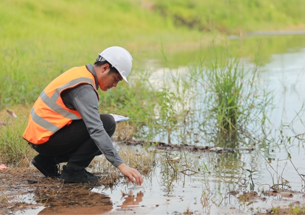 Engineer testing water outdoors.